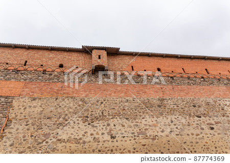 brick wall of an old castle with toilet room 87774369