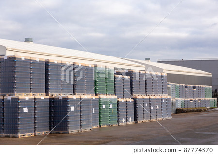 Outdoors warehouse with packages of brown and green bottles Outdoors warehouse with packages of brown and green bottles 87774370