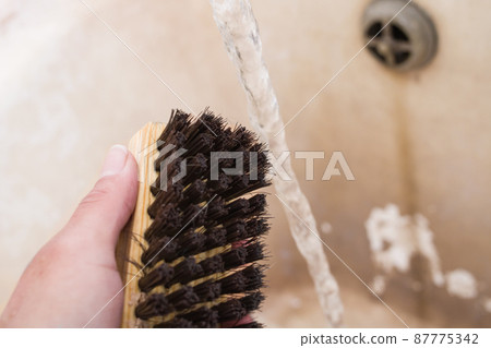 Shoe brush in hand and water jet Shoe brush in hand and water jet 87775342