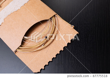 Guitar strings in cardboard packing close up 87775518