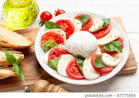 Caprese salad with mozzarella, basil and garden tomatoes 87775885