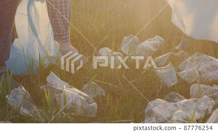 Volunteer team of people collect garbage plastic in garbage bags together, life without garbage, free the planet from pollution, happy family, do good deeds, teamwork 87776254