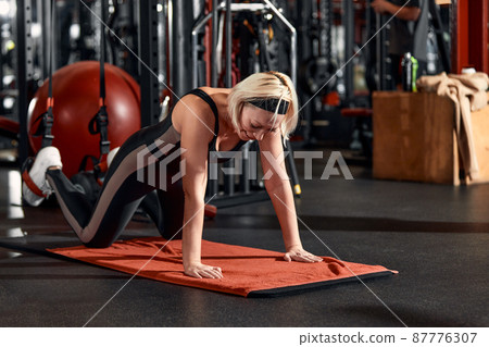 Young and active people on group sports training together do warming up and doing exercise for arm stretch. People train in spacious bright gym. Concept of sport and healthy lifestyle 87776307