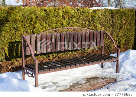 Wooden bench and bush in the snow Wooden bench and bush in the snow 87776683