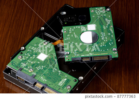 Computer Hard Drives on a Wooden Table Top Computer Hard Drives on a Wooden Table Top 87777363
