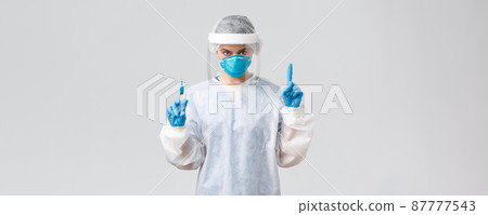 Covid-19, medical research, diagnosis, healthcare workers and quarantine concept. Determined doctor in PPE costume, personal protective equipment, hold syringe with coronavirus vaccine for patient 87777543