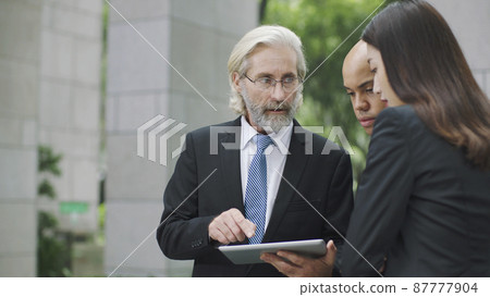 corporate executives discussing business using digital tablet corporate executives discussing business using digital tablet 87777904