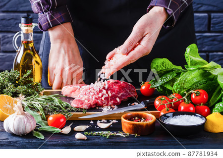 chef is sprinkling salt on strip loin steaks chef is sprinkling salt on strip loin steaks 87781934
