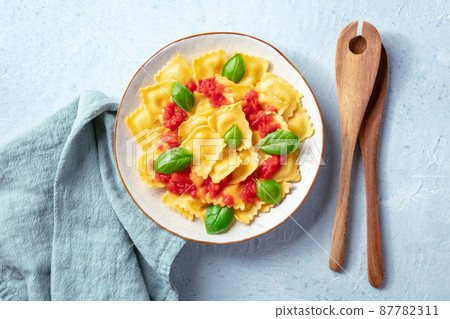 Ravioli with tomato sauce and basil. A plate of stuffed pasta, shot from above 87782311
