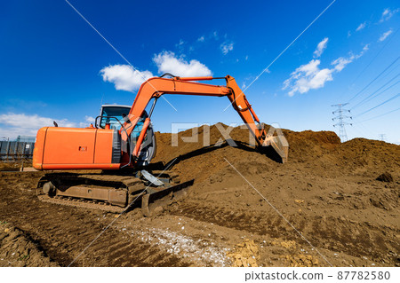 Construction site heavy equipment backhoe and clear blue sky 87782580