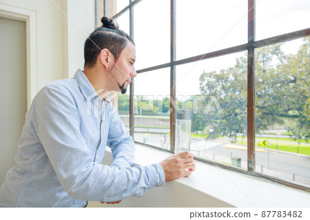 A man looking out the window 87783482