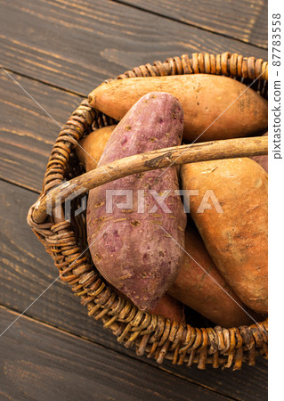 Sweet potato tubers in a wicker basket 87783558