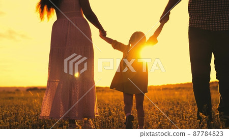 silhouette cheerfully playing girl sunset. child with parents cheerfully jumps runs sun. happy family life together. summer time family vacation. child kid with mother father walk hand park. outside. silhouette cheerfully playing girl sunset. child with parents cheerfully jumps runs sun. happy family life together. summer time family vacation. child kid with mother father walk hand park. outside. 87784823