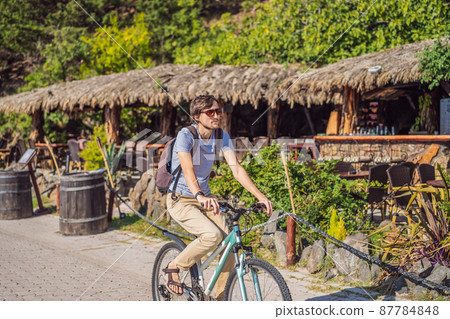 Man tourist on a bicycle explores Budva in Montenegro. Cycling in Montenegro concept Man tourist on a bicycle explores Budva in Montenegro. Cycling in Montenegro concept 87784848