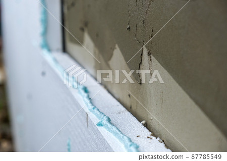 Installation of styrofoam insulation sheets on house facade wall for thermal protection. 87785549