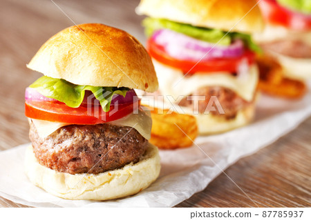 Mini hamburgers with tomato, salad and cheese on wooden board 87785937