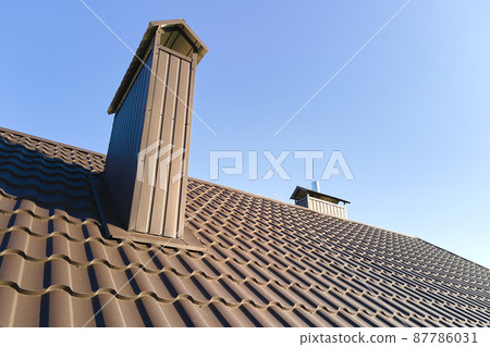Chimney on house roof top covered with metallic shingles under construction. Tiled covering of building. Real estate development 87786031