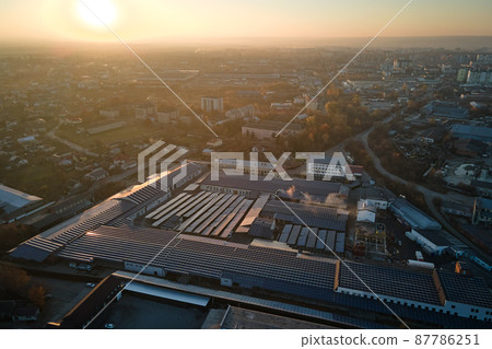 Aerial view of blue photovoltaic solar panels mounted on industrial building roof for producing green ecological electricity. Production of sustainable energy concept 87786251