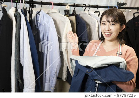 Women cleaning up men's clothing 87787229
