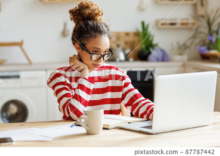 Young focused African-American woman freelancer , enjoying remote work at home office 87787442