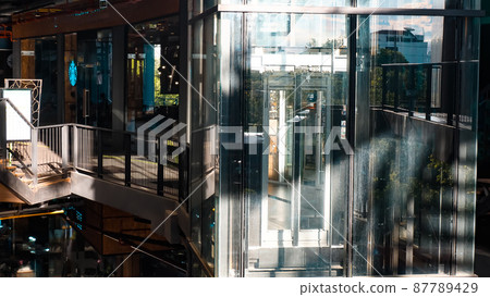 Sunlight through Glass elevator with no people in shopping mall Sunlight through Glass elevator with no people in shopping mall 87789429