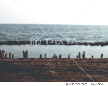 Blur tropical beach with bokeh sun light wave on empty old nature wood table abstract background. Product presentation in nature. Blur tropical beach with bokeh sun light wave on empty old nature wood table abstract background. Product presentation in nature. 87789568