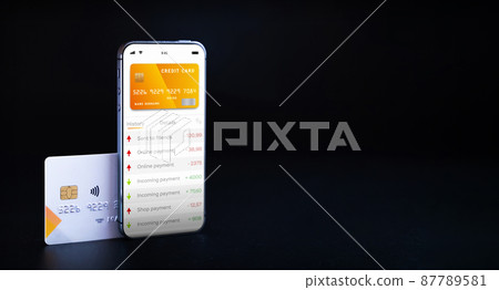 Online payment. Mobile phone with internet online bank app. Credit card on black background. Online wallet save money. Online payment. Mobile phone with internet online bank app. Credit card on black background. Online wallet save money. 87789581