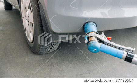 Gas station. Pump fuel petrol in tank car. Gasoline oil in nozzle. Close-up of the hand and the fuel gun. Blurred background. Gas station. Pump fuel petrol in tank car. Gasoline oil in nozzle. Close-up of the hand and the fuel gun. Blurred background. 87789594