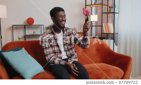 Man blogger influencer taking selfie on smartphone, make virtual social media video online at home Man blogger influencer taking selfie on smartphone, make virtual social media video online at home 87789722