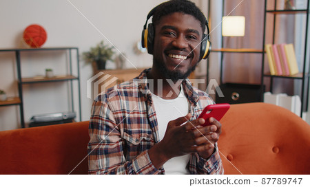 African American young man in headphones listening music dancing 87789747