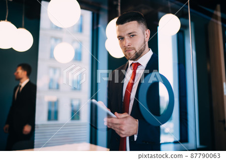 Confident man with tablet in office Confident man with tablet in office 87790063