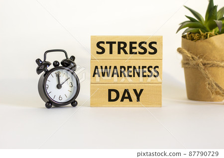 Stress awareness day symbol. Wooden blocks with words 'Stress awareness day'. Beautiful white background. Black alarm clock. Psychological, business and stress awareness day concept. Copy space. Stress awareness day symbol. Wooden blocks with words 'Stress awareness day'. Beautiful white background. Black alarm clock. Psychological, business and stress awareness day concept. Copy space. 87790729