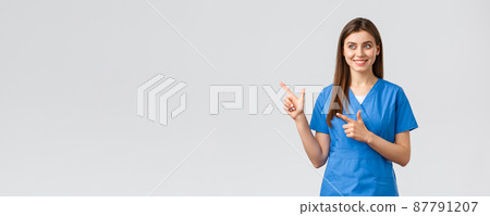 Healthcare workers, prevent virus, insurance and medicine concept. Smiling pretty nurse or doctor in blue scrubs, pointing fingers left and looking at baner with pleased grin, grey background 87791207