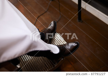 Elegant leather shoes on a man who is sitting in an armchair Elegant leather shoes on a man who is sitting in an armchair 87791227