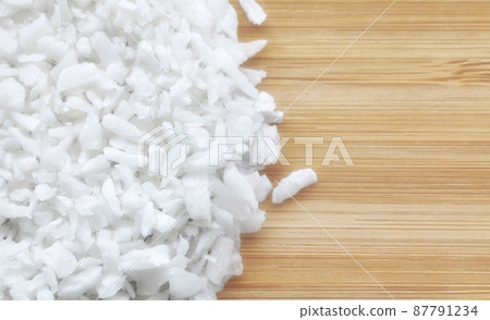 Close up picture of coconut shreds on a wooden background, selective focus. Close up picture of coconut shreds on a wooden background, selective focus. 87791234