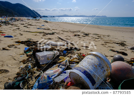 Marine debris washed ashore on a beautiful crystal beach 87793585