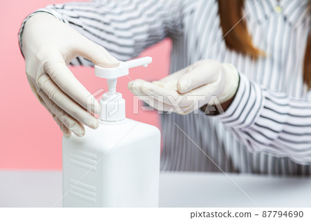 Hygiene during coronavirus quarantine. Closeup woman in shirt using sanitizer, cleaning hands with antiseptic gel. Disinfection at workplace, home office. Preventive measures in covid-19 epidemic 87794690