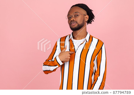 Proud self confident african man with dreadlocks in stylish shirt egoistically pointing finger on himself, boasting and admiring his merits. Indoor studio shot isolated on pink background Proud self confident african man with dreadlocks in stylish shirt egoistically pointing finger on himself, boasting and admiring his merits. Indoor studio shot isolated on pink background 87794789