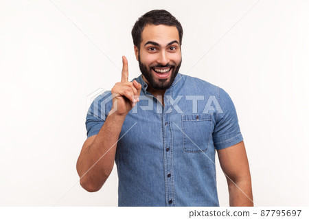 Eureka. Clever smiling man with beard pointing finger up, has good idea genius plan, inspiration and creativity. Indoor studio shot isolated on white background 87795697