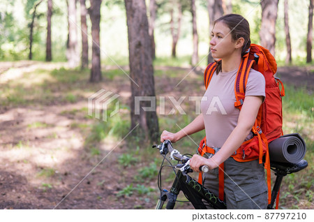 Caucasian woman rides a bicycle in the forest Caucasian woman rides a bicycle in the forest 87797210