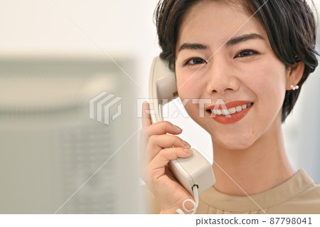 一位女士在辦公室的磁盤計算機前打電話 87798041