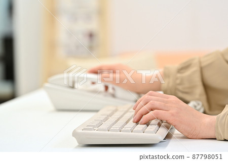 一個女人在敲鍵盤時伸手去拿聽筒 87798051