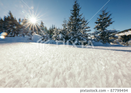 A man riding a snowboard down a snow covered slope A man riding a snowboard down a snow covered slope 87799494