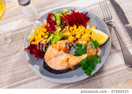 Fried salmon steak with a light vegetable salad Fried salmon steak with a light vegetable salad 87800435