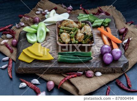 Thai food, Stir Fried fish ball with Red Curry Paste and long bean with the ingredient and fresh vegetables on wood background. Thai food, Stir Fried fish ball with Red Curry Paste and long bean with the ingredient and fresh vegetables on wood background. 87800494
