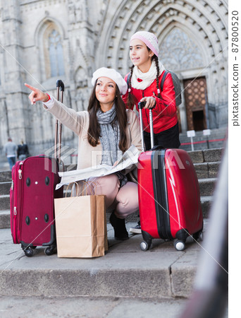 girl with mother holding map outdoors girl with mother holding map outdoors 87800520