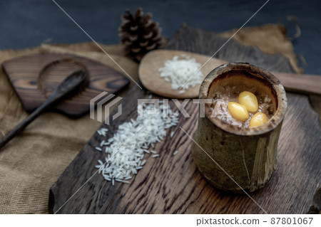 Sticky Rice Cooked with Coconut milk (Khao lam) or Glutinous rice roasted in bamboo joints on wooden, Thai dessert concept. 87801067
