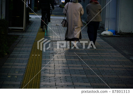 People walking on the sidewalk in the dark People walking on the sidewalk in the dark 87801313