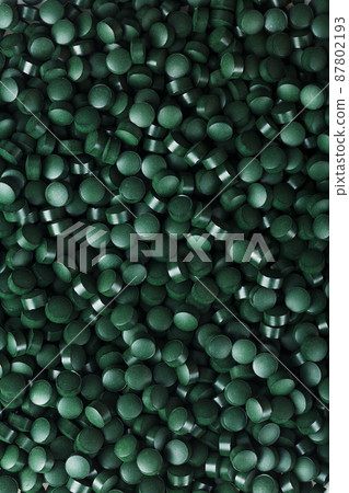 Dark Green round tablets of organic spirulina as a texture Dark Green round tablets of organic spirulina as a texture 87802193
