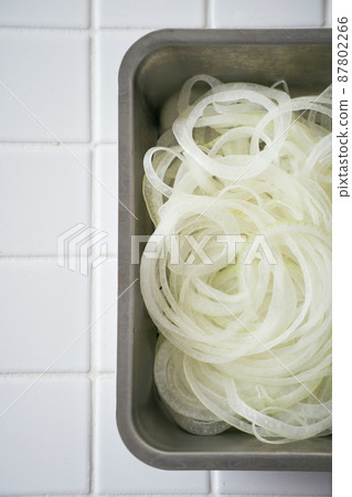 Onion slices on a cooking vat 87802266
